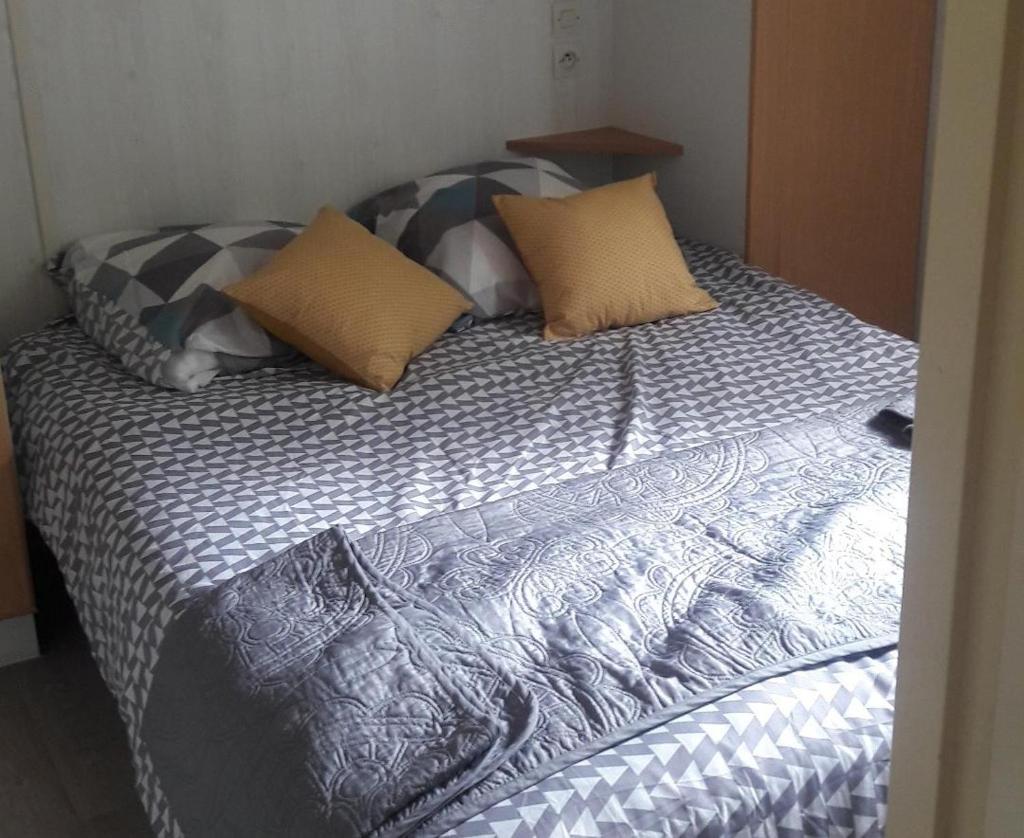 un lit avec des oreillers dessus dans une chambre dans l'établissement Chalet les Hameaux du Perrier, à Lissac-sur-Couze