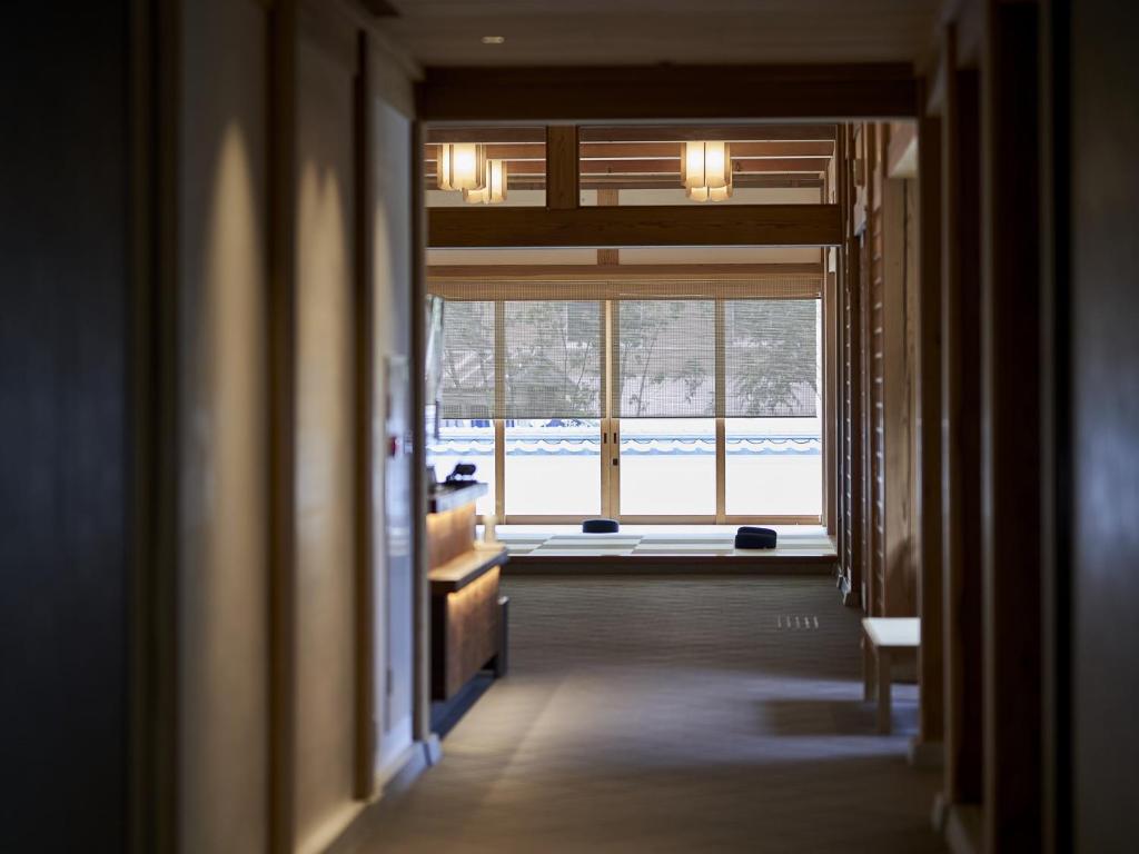 - un couloir avec vue sur une chambre dotée d'une fenêtre dans l'établissement Hakujukan, à Eiheiji