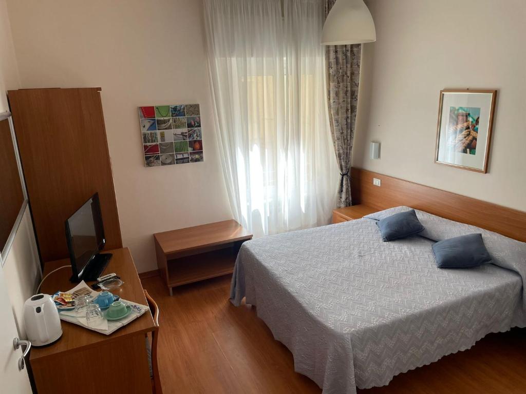 une chambre d'hôtel avec un lit et une télévision dans l'établissement Hotel Stazione del Sole, à Albenga