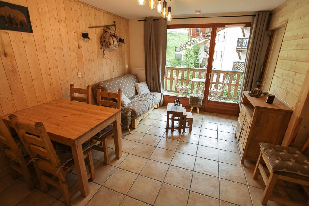 un salon avec une table en bois et un canapé dans l'établissement L'Alpin- Appartement 2ch au pied des pistes- tarif lits faits et linge de toilette compris, à Aussois