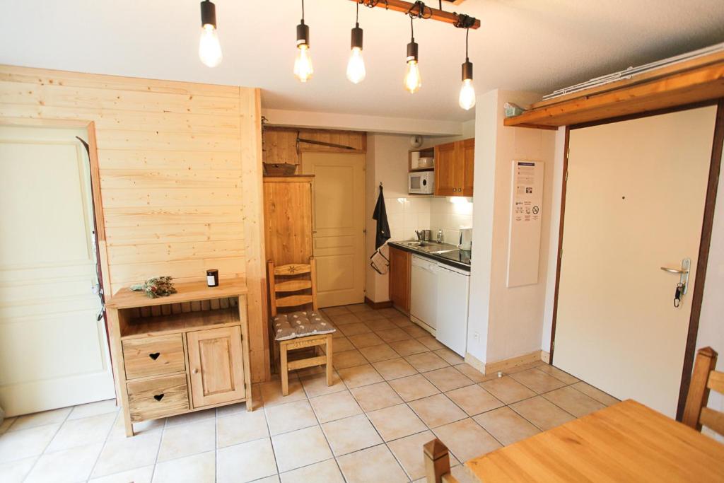- une cuisine avec des murs en bois, une table et un comptoir dans l'établissement L'Alpin- Appartement 2ch au pied des pistes- tarif lits faits et linge de toilette compris, à Aussois 9 autres photos