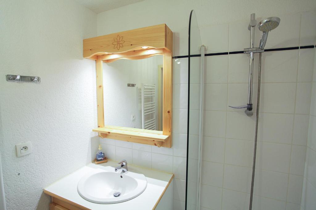 une salle de bain avec un lavabo et une douche avec un miroir dans l'établissement L'Alpin- Appartement 2ch au pied des pistes- tarif lits faits et linge de toilette compris, à Aussois