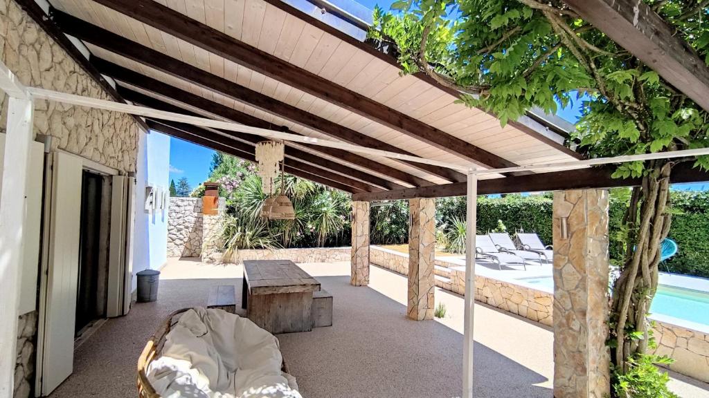 un patio avec une pergola en bois à côté d'une piscine dans l'établissement Villa Agave, à Lazise