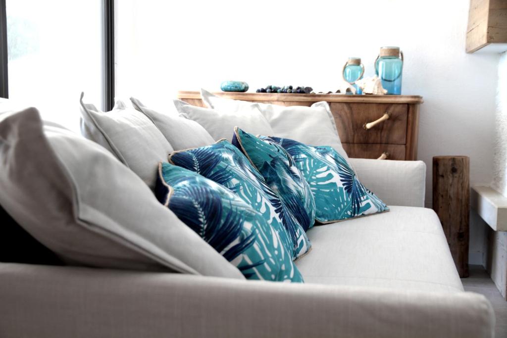 - un canapé avec des oreillers bleus et blancs dans l'établissement Villa Agave, à Lazise