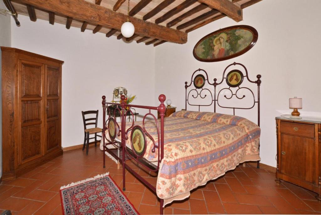une chambre avec un lit et une armoire en bois dans l'établissement Villa Piombona, à Anghiari 34 autres photos