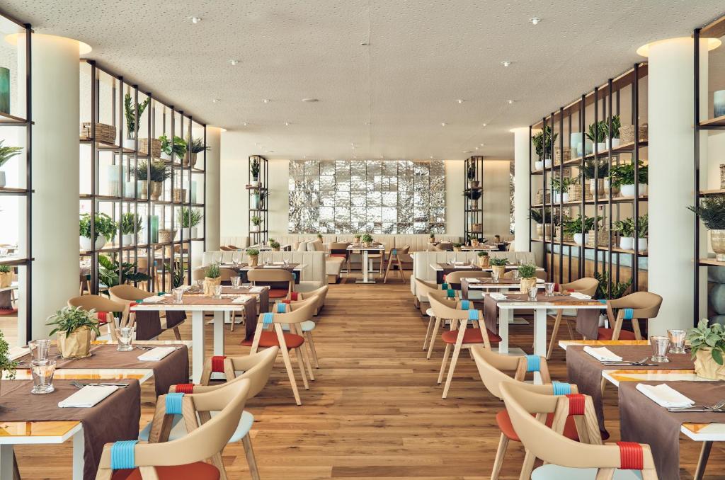 un rendu d'un restaurant avec des tables et des chaises dans l'établissement Falkensteiner Hotel & Spa Jesolo, à Lido di Jesolo