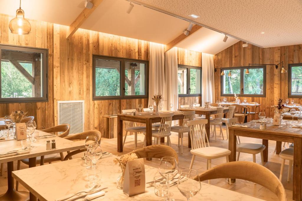 un restaurant avec des murs en bois, des tables et des chaises dans l'établissement Mercure Peyragudes Loudenvielle Pyrénées, à Loudenvielle