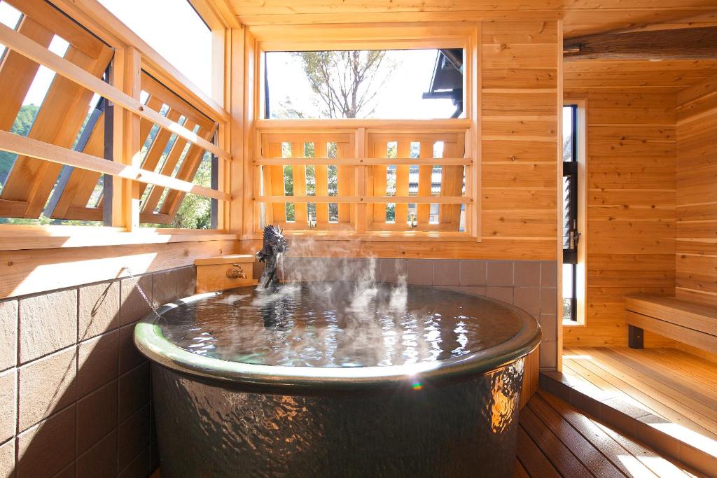 Cette chambre en bois comprend une grande baignoire et une fontaine. dans l'établissement Goyokan, à Izu 13 autres photos