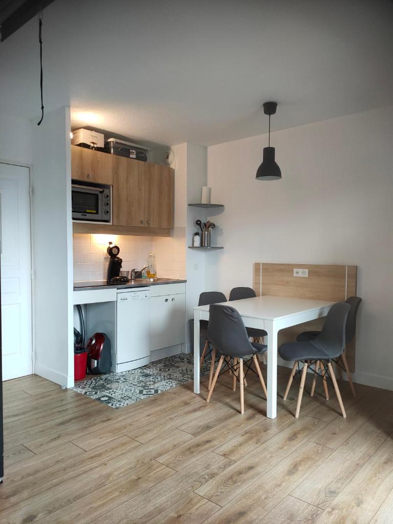 une cuisine et une salle à manger avec une table et des chaises dans l'établissement Risoul Appartement Rénové Piscine Balcons de Sirius, à Risoul