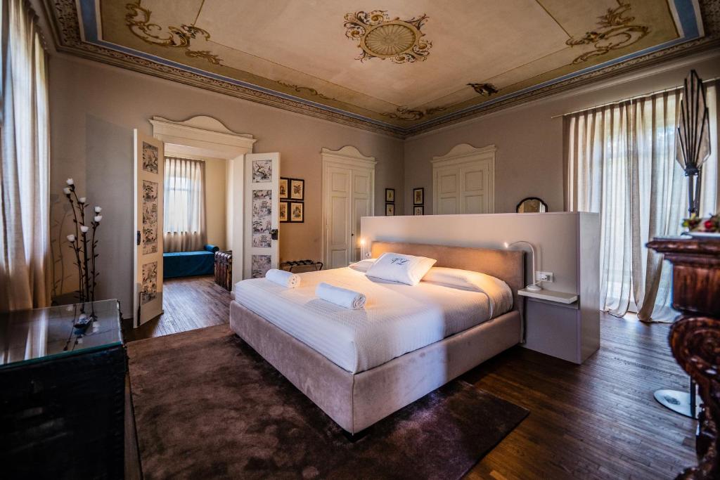 une chambre avec un grand lit dans une pièce dans l'établissement Villa Leolo' Monforte d'Alba, à Monforte dʼAlba