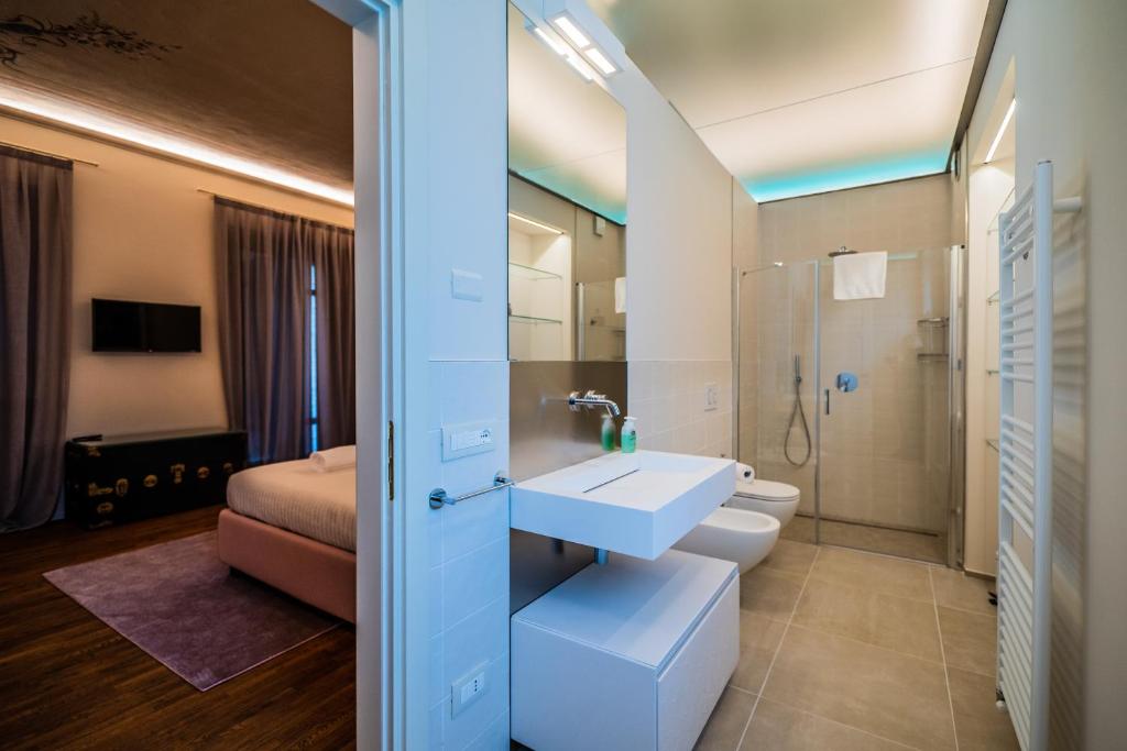 une salle de bain avec un lavabo et des toilettes et un lit dans l'établissement Villa Leolo' Monforte d'Alba, à Monforte dʼAlba