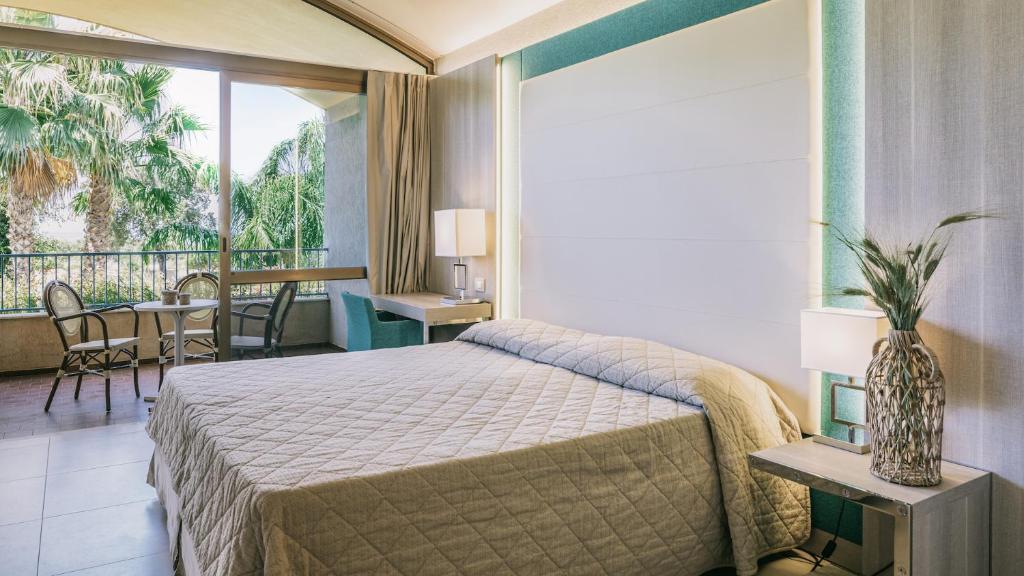une chambre d'hôtel avec un lit et un balcon dans l'établissement MClub Alicudi, à Sciacca