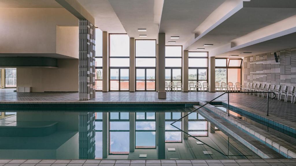 - une piscine dans un bâtiment avec fenêtres dans l'établissement MClub Cala Regina, à Sciacca