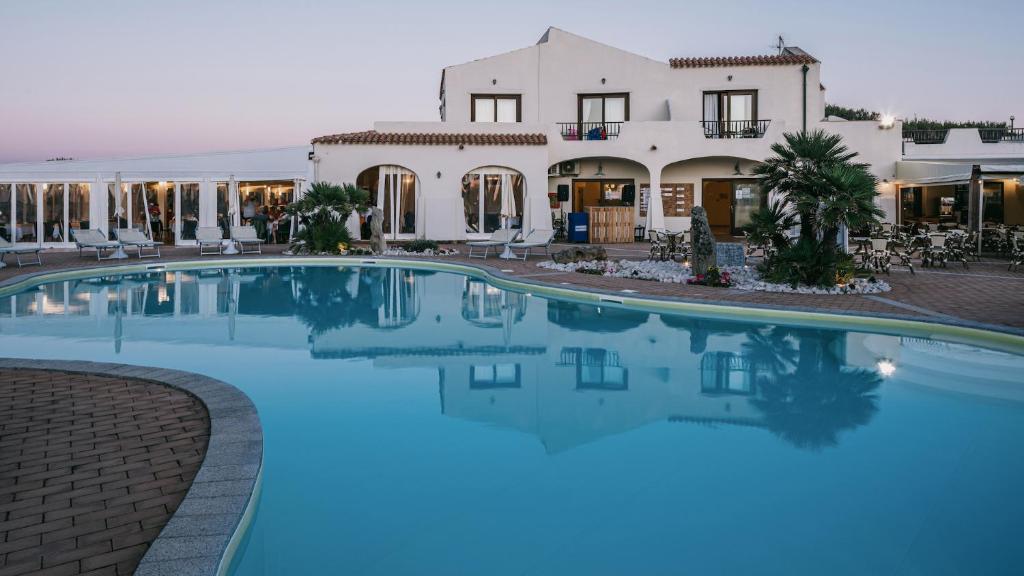 une grande piscine devant une maison dans l'établissement MClub Del Golfo, à Sorso
