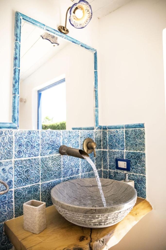 La salle de bains est pourvue d'un lavabo et de carrelage bleu. dans l'établissement Dimora Fanale, Villa Esclusiva con Piscina Privata - Fanale Rentals, à Altavilla Milicia