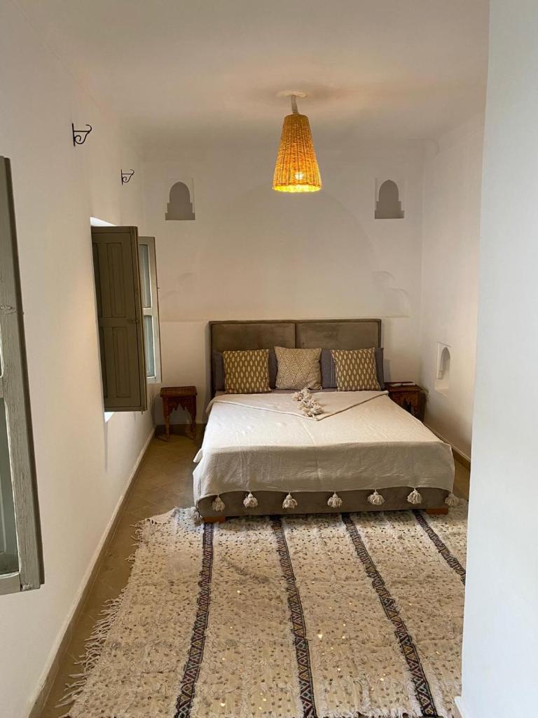 une chambre avec un lit et un lustre dans l'établissement Private house Riad Arlette exclusive, à Marrakech