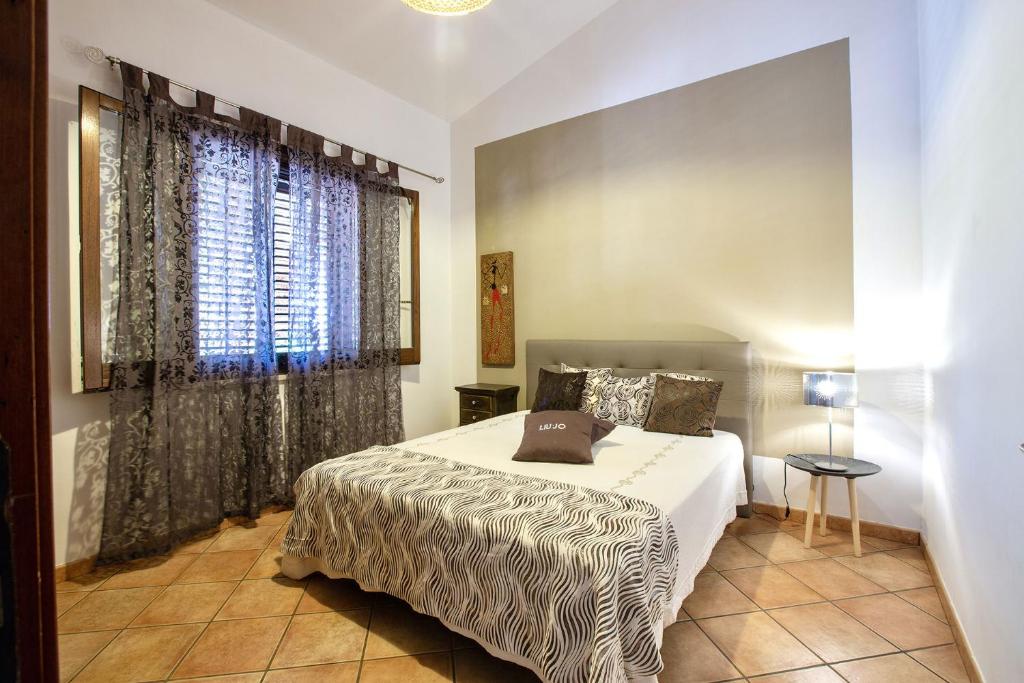 une chambre avec un lit et une grande fenêtre dans l'établissement Villa Isabella, à Castellammare del Golfo