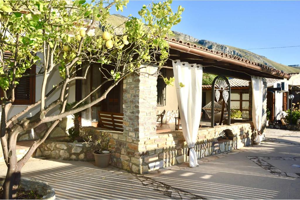 une maison avec un arbre devant dans l'établissement Villa Isabella, à Castellammare del Golfo