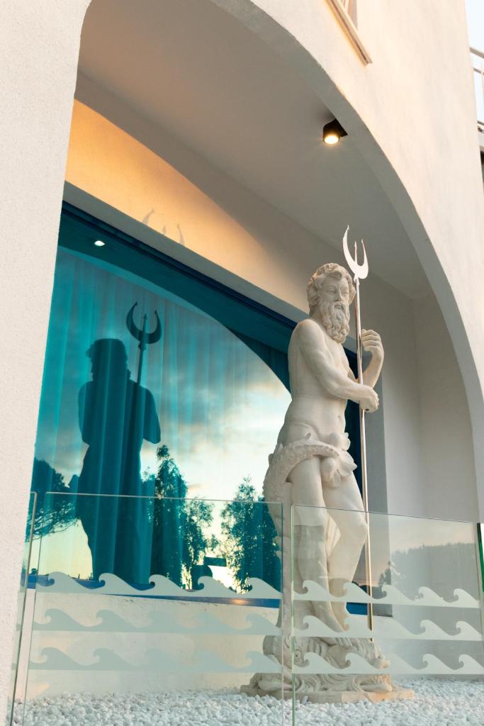 une statue d'un homme tenant un trident dans une fenêtre dans l'établissement Hotel Poseidonia Mare, à Paestum