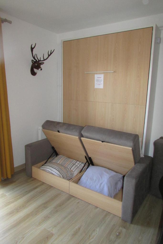 - un lit dans une chambre avec une tête de cerf sur le mur dans l'établissement Superbe studio Les Angles, aux Angles