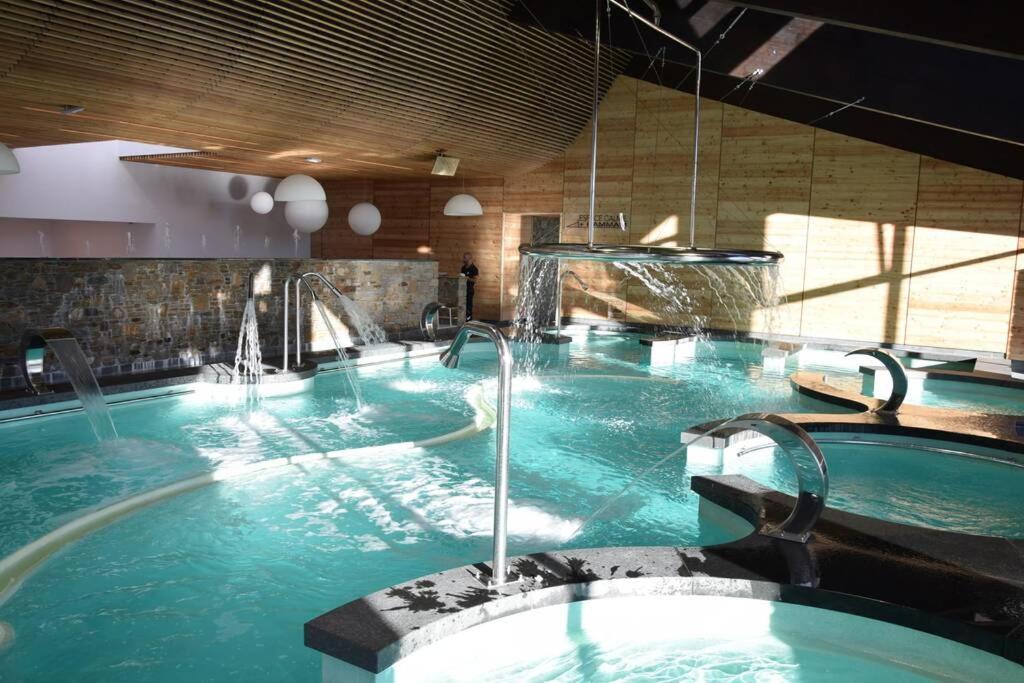 une grande piscine d'eau bleue dans un bâtiment dans l'établissement Superbe studio Les Angles, aux Angles