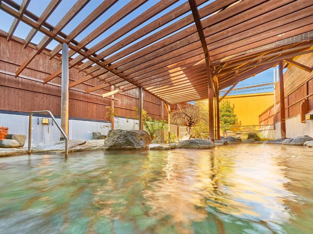 - une piscine dans un bâtiment doté d'un plafond en bois dans l'établissement Ooedo Onsen Monogatari Ureshinokan, à Ureshino