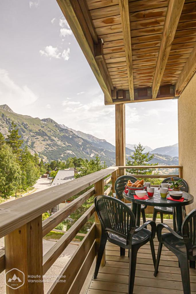 une table et des chaises sur un balcon avec vue dans l'établissement Le chalet d'Isis - La Norma, à Villarodin-Bourget 7 autres photos