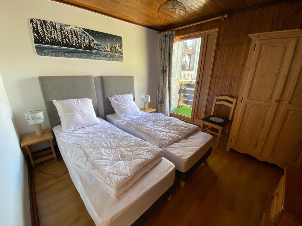 deux lits jumeaux dans une chambre avec fenêtre dans l'établissement Tignes duplex 8-10 p avec parking, à Tignes
