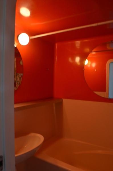 La salle de bains est pourvue de murs rouges, d'un lavabo et de toilettes. dans l'établissement PIERRA MENTA ARC 1800 Studio Appartement - 5 per, à Arc 1800