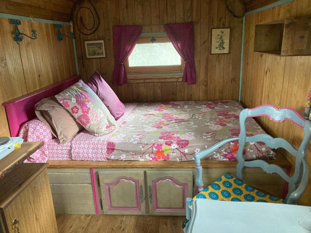 - une chambre avec un lit dans une maison de poupées dans l'établissement La Roulotte Cavalière, au cœur d'une manade en Camargue, à Mas-Thibert
