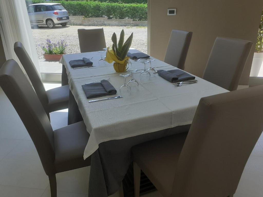 - une table à manger avec une nappe et des chaises blanches dans l'établissement Hotel Rodian, à Acquappesa
