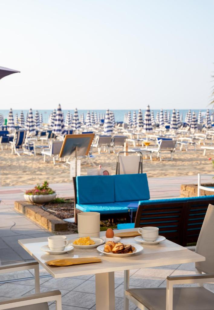 - une table avec des assiettes de nourriture au-dessus d'une plage dans l'établissement Hotel Telenia, à Lido di Jesolo