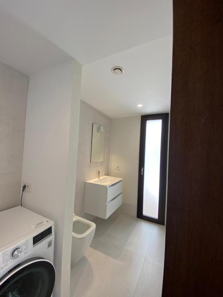 une salle de bain blanche avec toilettes et lavabo dans l'établissement Domo La Vela, à Cala Liberotto