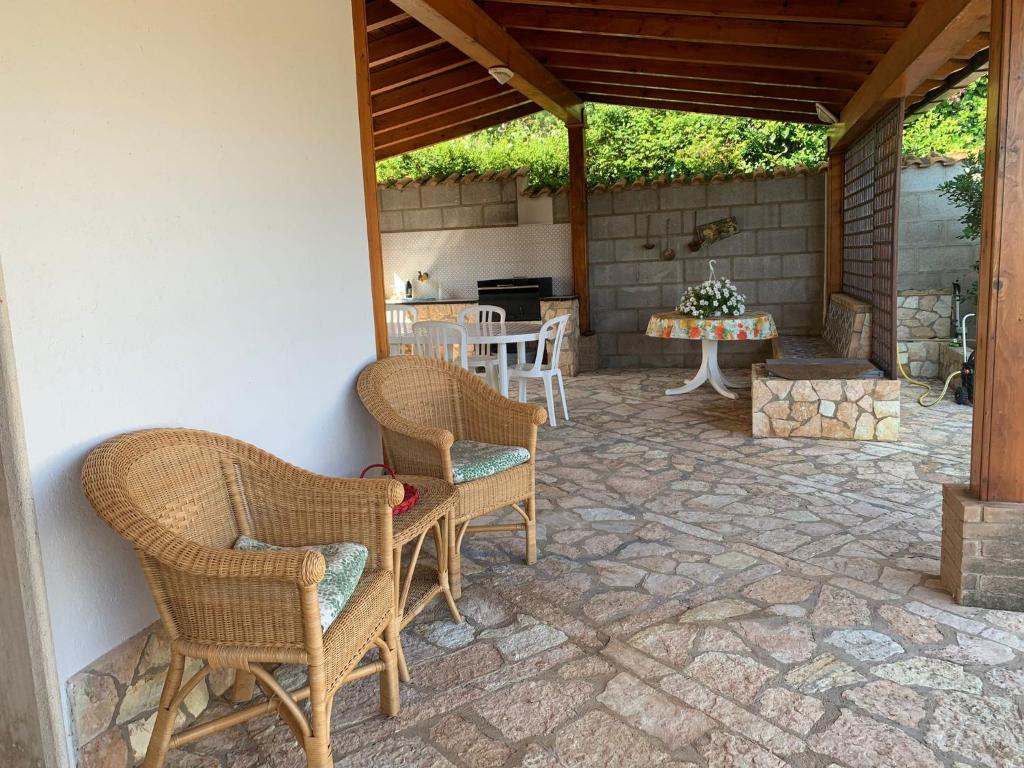 un patio avec des chaises en osier et une table dans l'établissement Villa Cycas Costamante, à Castellammare del Golfo