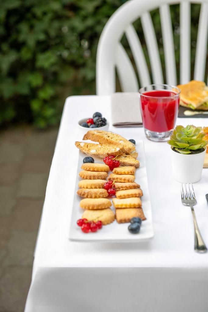 une assiette blanche avec des biscuits et des baies sur une table dans l'établissement Hotel Eliseo Riccione, à Riccione