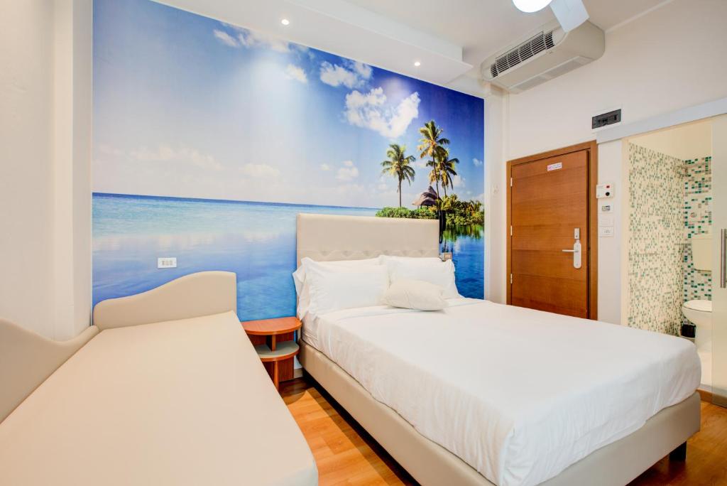 deux lits dans une chambre avec une fresque de l'océan dans l'établissement Hotel Sympathy, à Rimini 110 autres photos