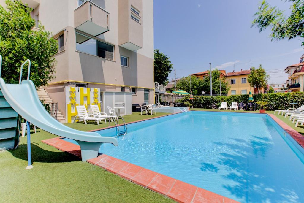 une piscine avec toboggan en face d'un bâtiment dans l'établissement Hotel Sympathy, à Rimini