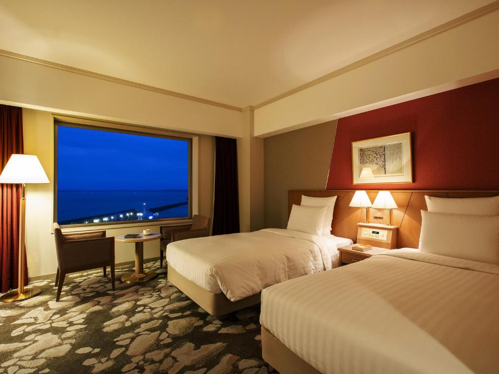 une chambre d'hôtel avec deux lits et une grande fenêtre dans l'établissement Surfeel Hotel Wakkanai, à Wakkanai 37 autres photos