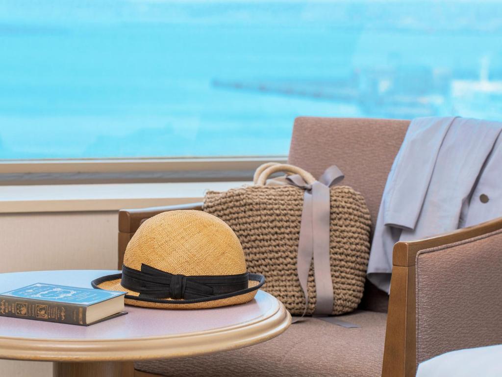 un chapeau et un livre sur une table avec un sac dans l'établissement Surfeel Hotel Wakkanai, à Wakkanai