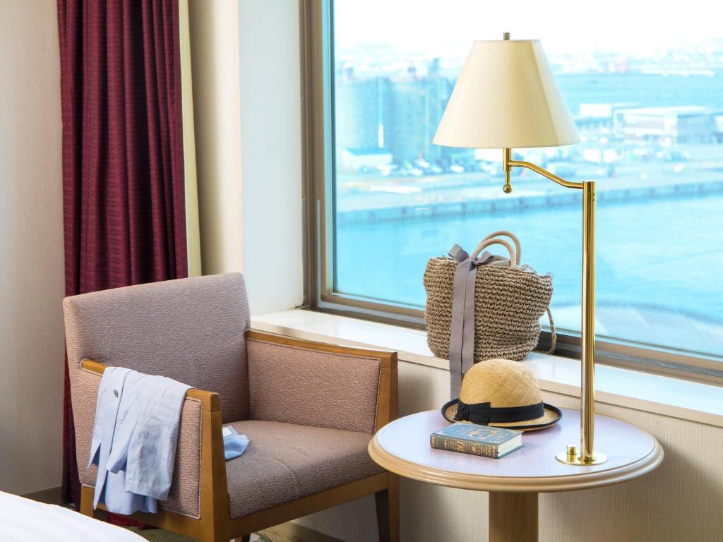 une chambre d'hôtel avec une table, une lampe et une fenêtre dans l'établissement Surfeel Hotel Wakkanai, à Wakkanai
