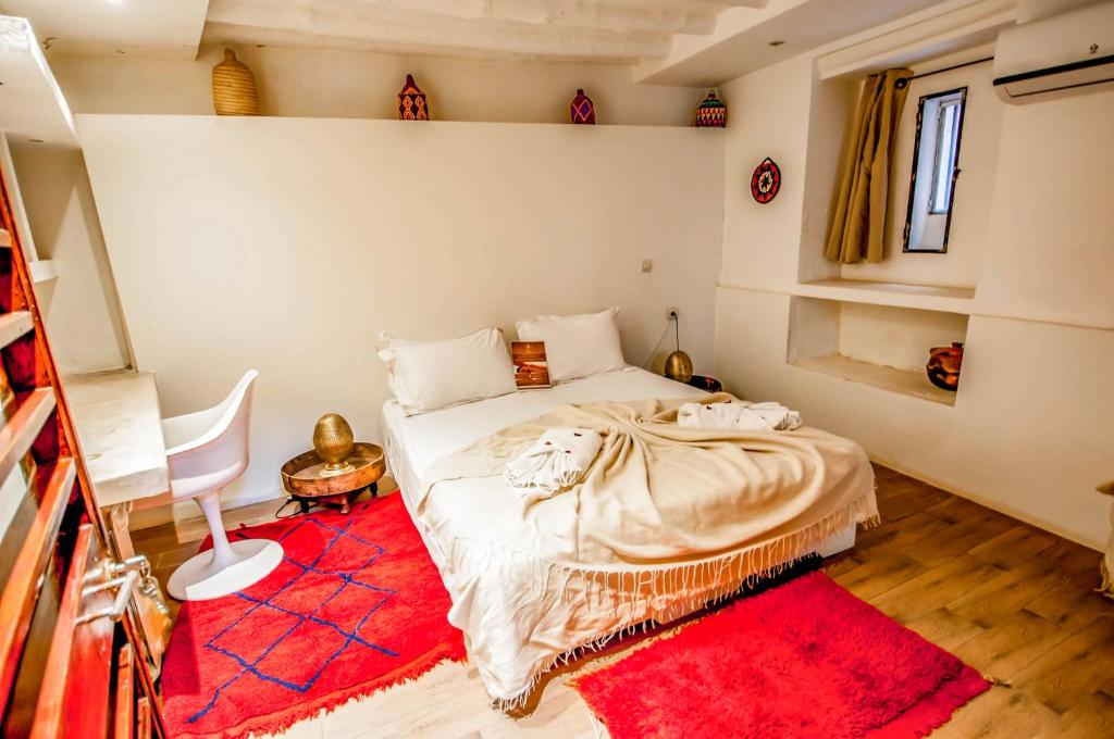 - une chambre avec un lit et un tapis rouge dans l'établissement Riad Chorfa, à Marrakech