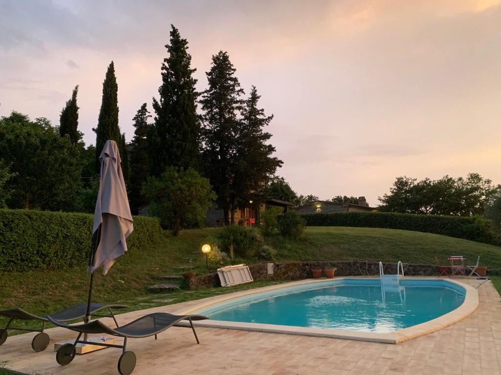 - une piscine avec un parasol à côté d'une cour dans l'établissement Villa Bellavista - Piscina ad uso esclusivo, à Celle sul Rigo