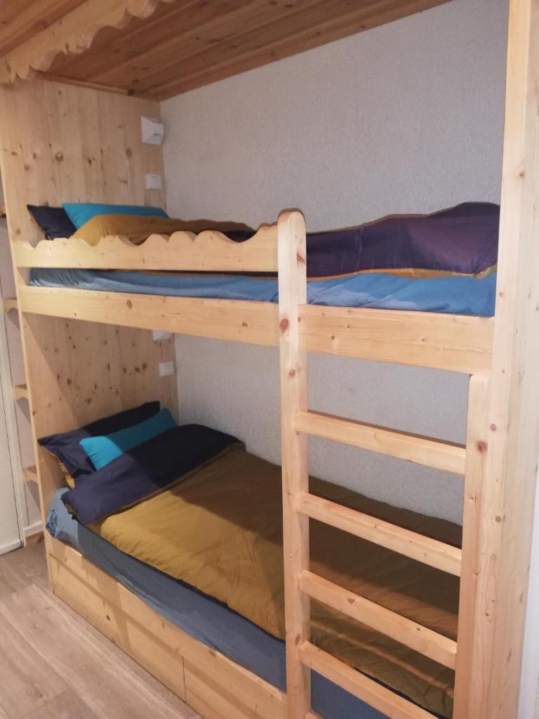 2 lits superposés dans une cabine avec des lits bleus et jaunes dans l'établissement Pra-Loup 1600, Front de Neige, à Pra-Loup
