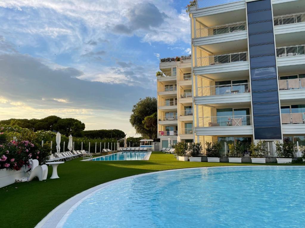 un hôtel avec une piscine devant un bâtiment dans l'établissement Marina Verde Resort Official, à Caorle