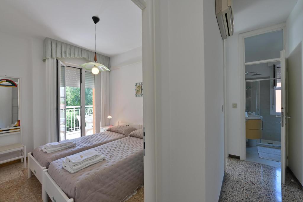 une chambre avec un lit et une grande fenêtre dans l'établissement Residence Mariavittoria, à Lido di Jesolo