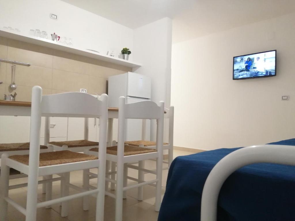 - une cuisine avec deux chaises blanches et une table dans l'établissement Villa Laura Residence Hotel Apartments & Studios, à Ascea