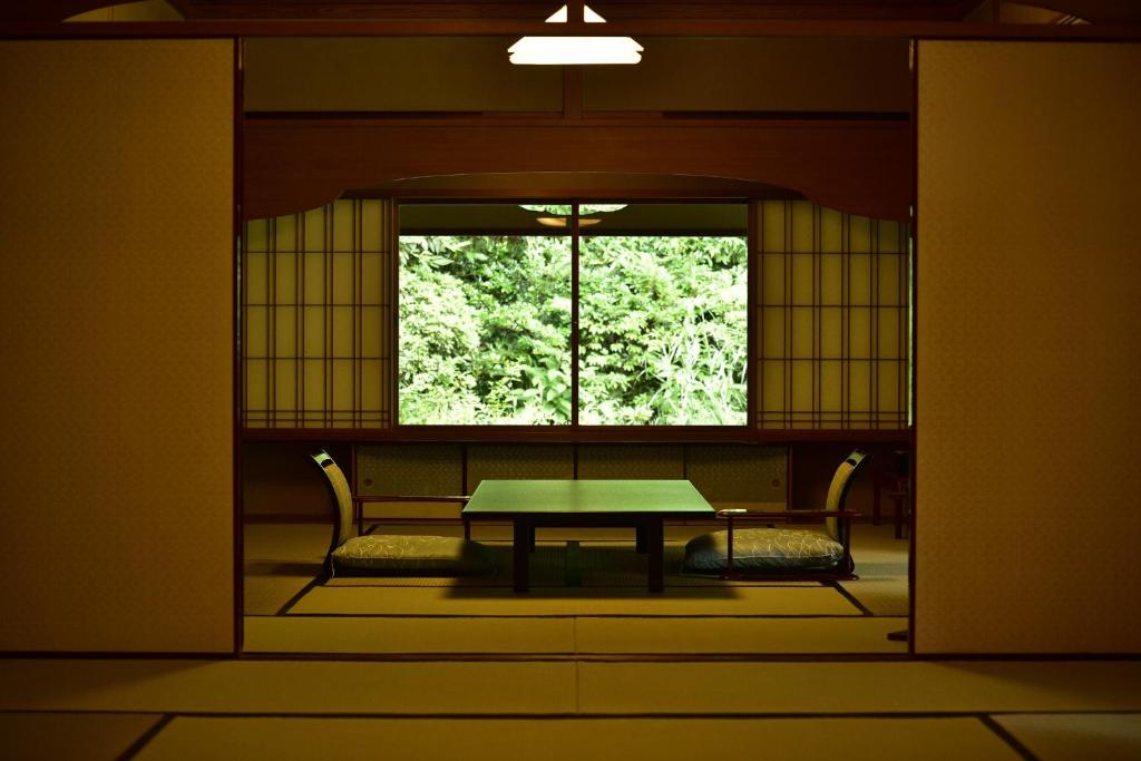 une pièce avec une table et deux chaises et une fenêtre dans l'établissement Sanyo-so, à Izunokuni 37 autres photos