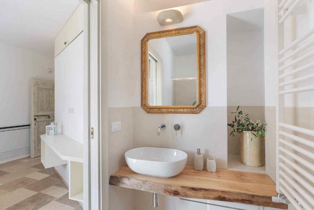 une salle de bain avec un lavabo blanc et un miroir dans l'établissement Trullo Juno, à Ostuni
