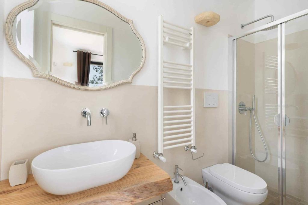 une salle de bain blanche avec un lavabo et un miroir dans l'établissement Trullo Juno, à Ostuni 34 autres photos