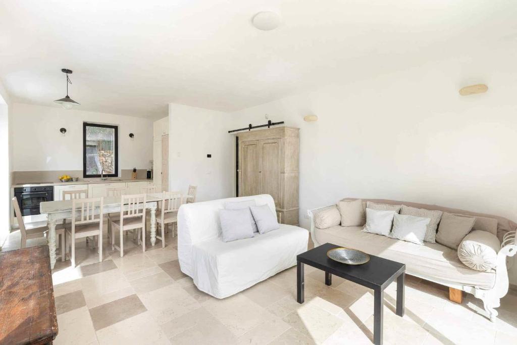 un salon avec un canapé blanc et une table dans l'établissement Trullo Juno, à Ostuni
